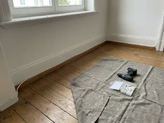 Câble d'alarme fixé proprement le long d'une plinthe